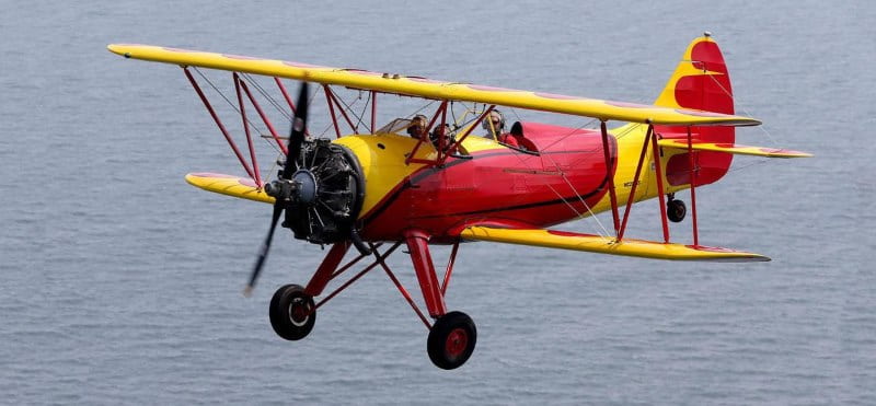 Image of a red barron airplane flying over the Jersey Shore showcasing a fun date idea in NJ